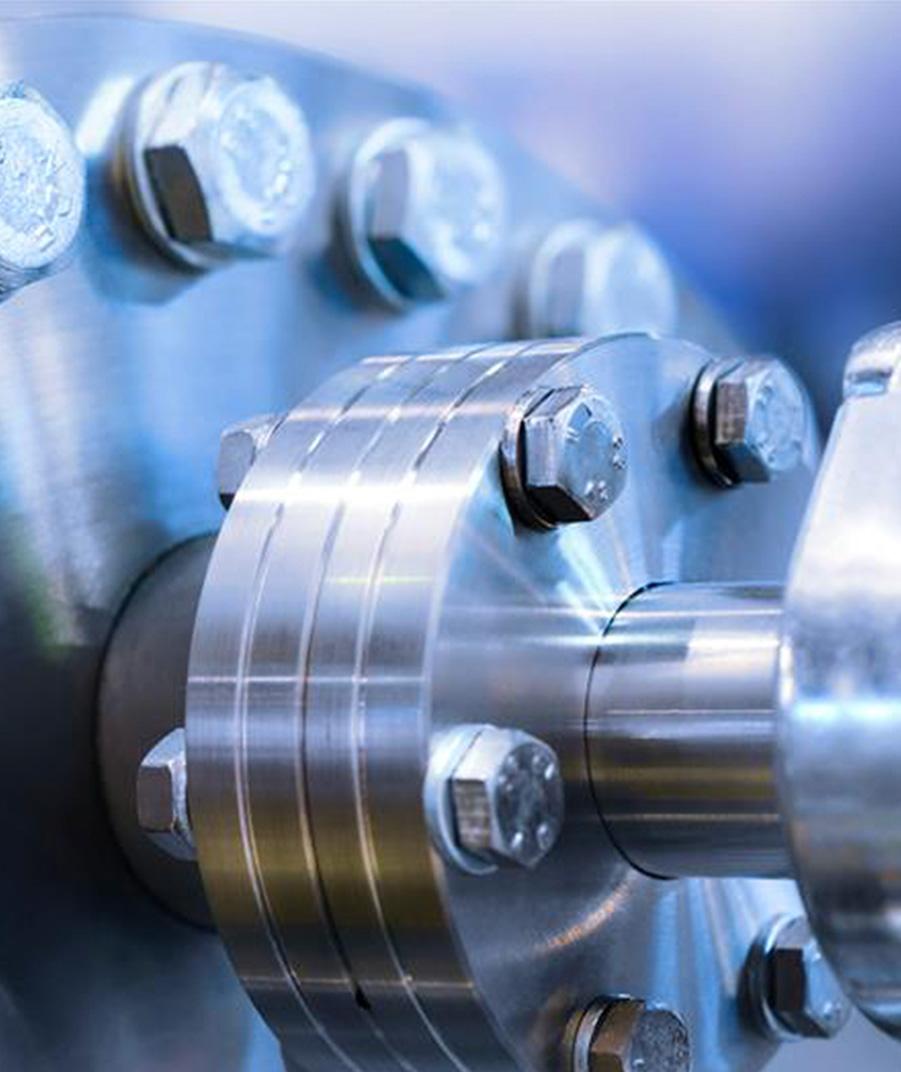 Vue rapprochée d'un raccord métallique industriel avec des boulons et un arbre en acier, utilisé dans des équipements mécaniques ou de vide industriel